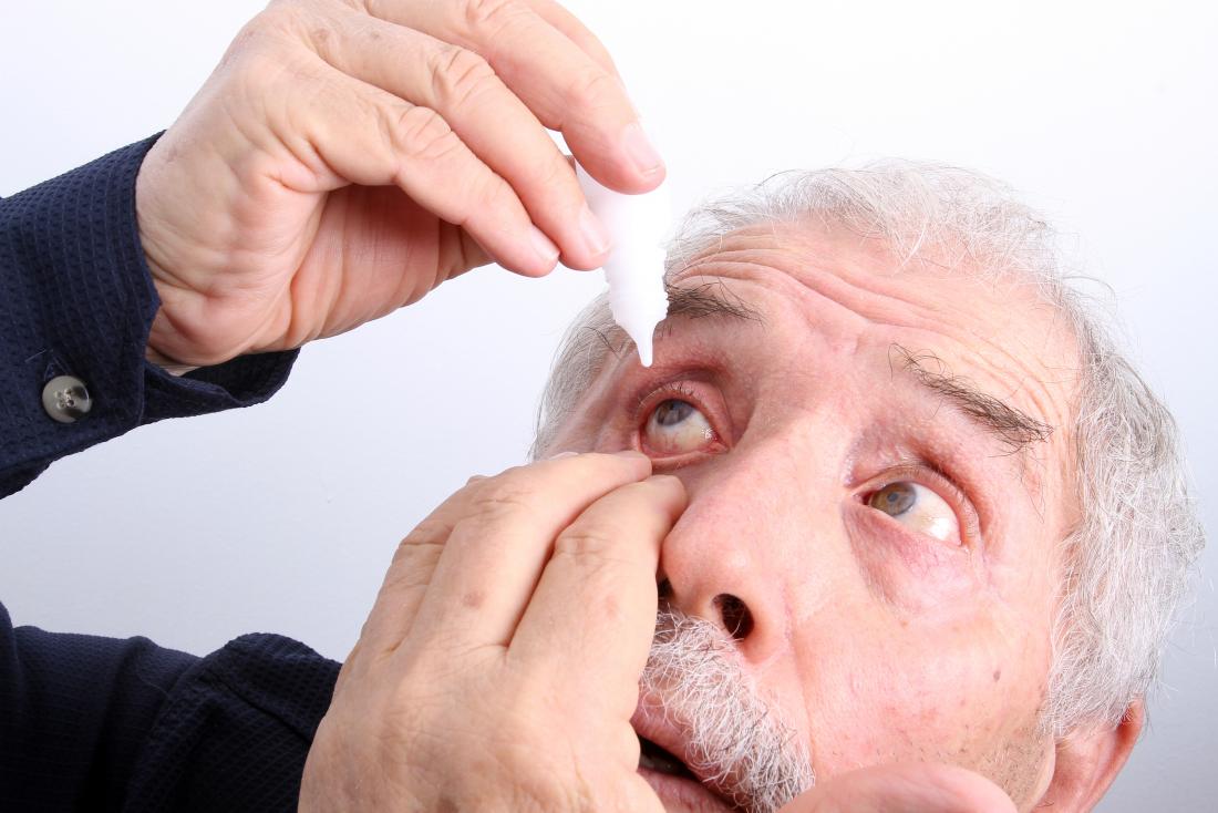 senior man applying eye drops because of burning eyes
